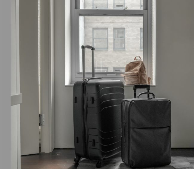 Suitcases in front of a window looking out on NYC buildings